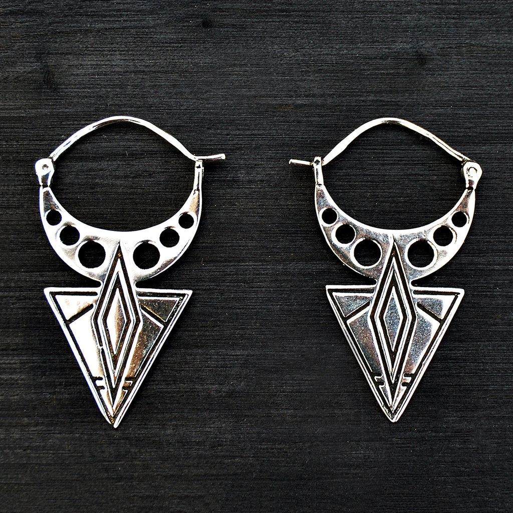Geometric silver aztec earrings on black background