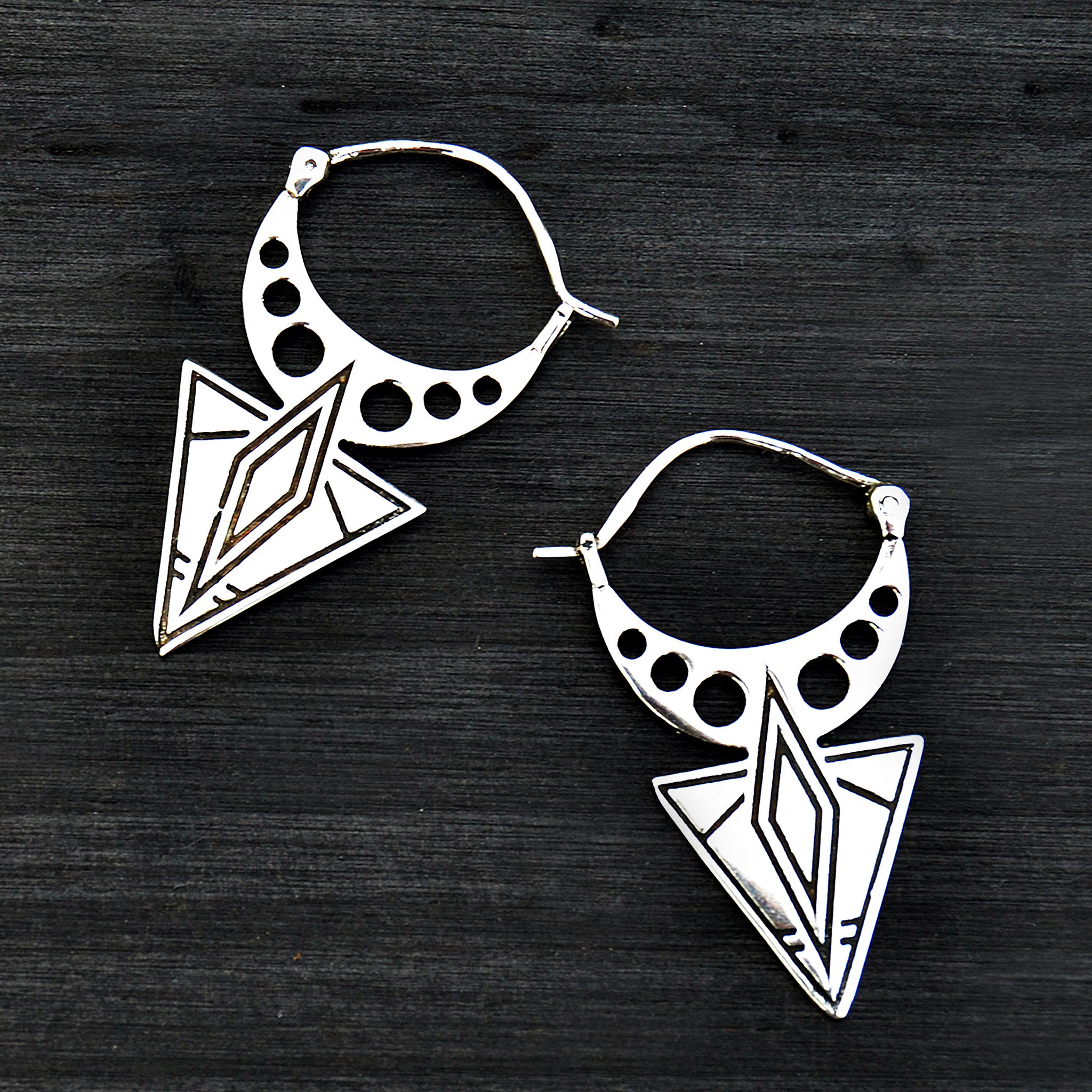 Silver aztec earrings on black background