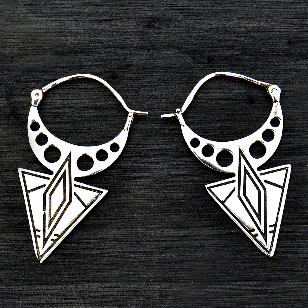 Silver tribal aztec earrings on black background