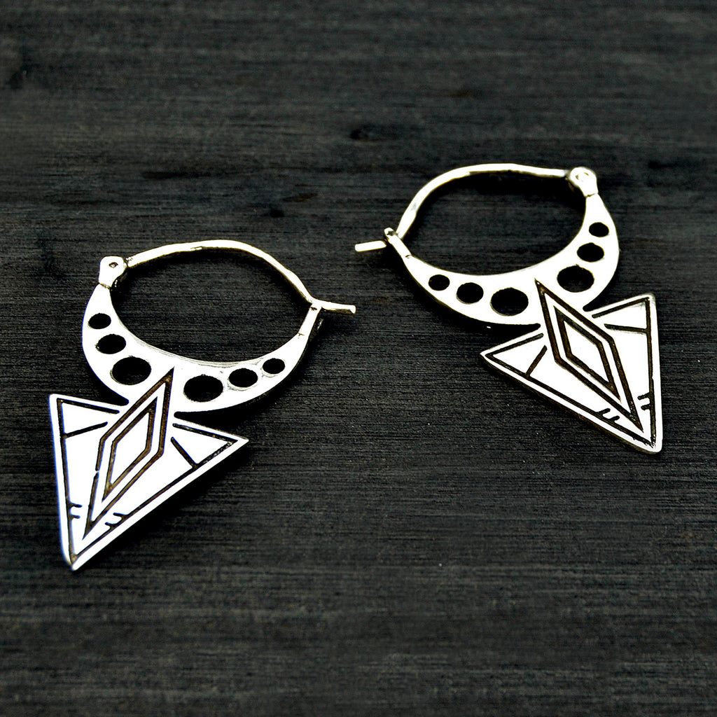 Silver geometric aztec spike earrings on black background