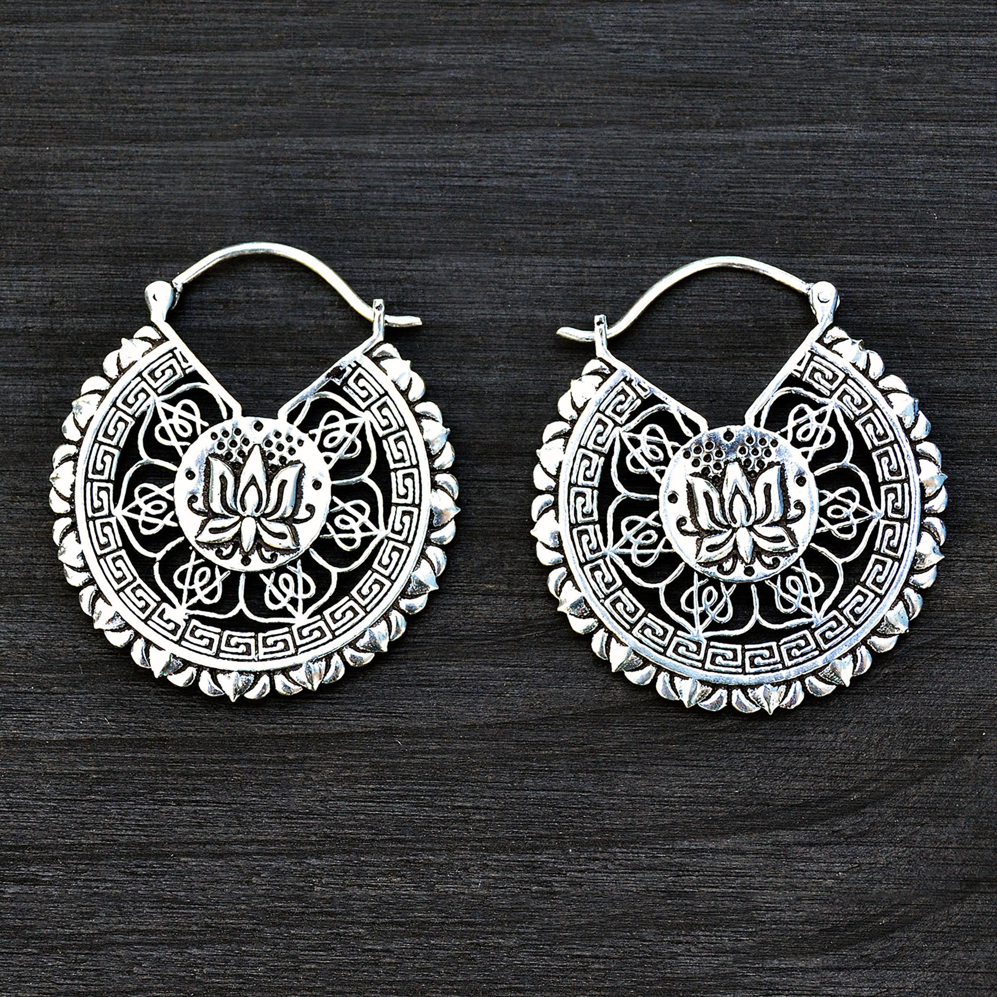 Tribal lotus mandala earrings on black background