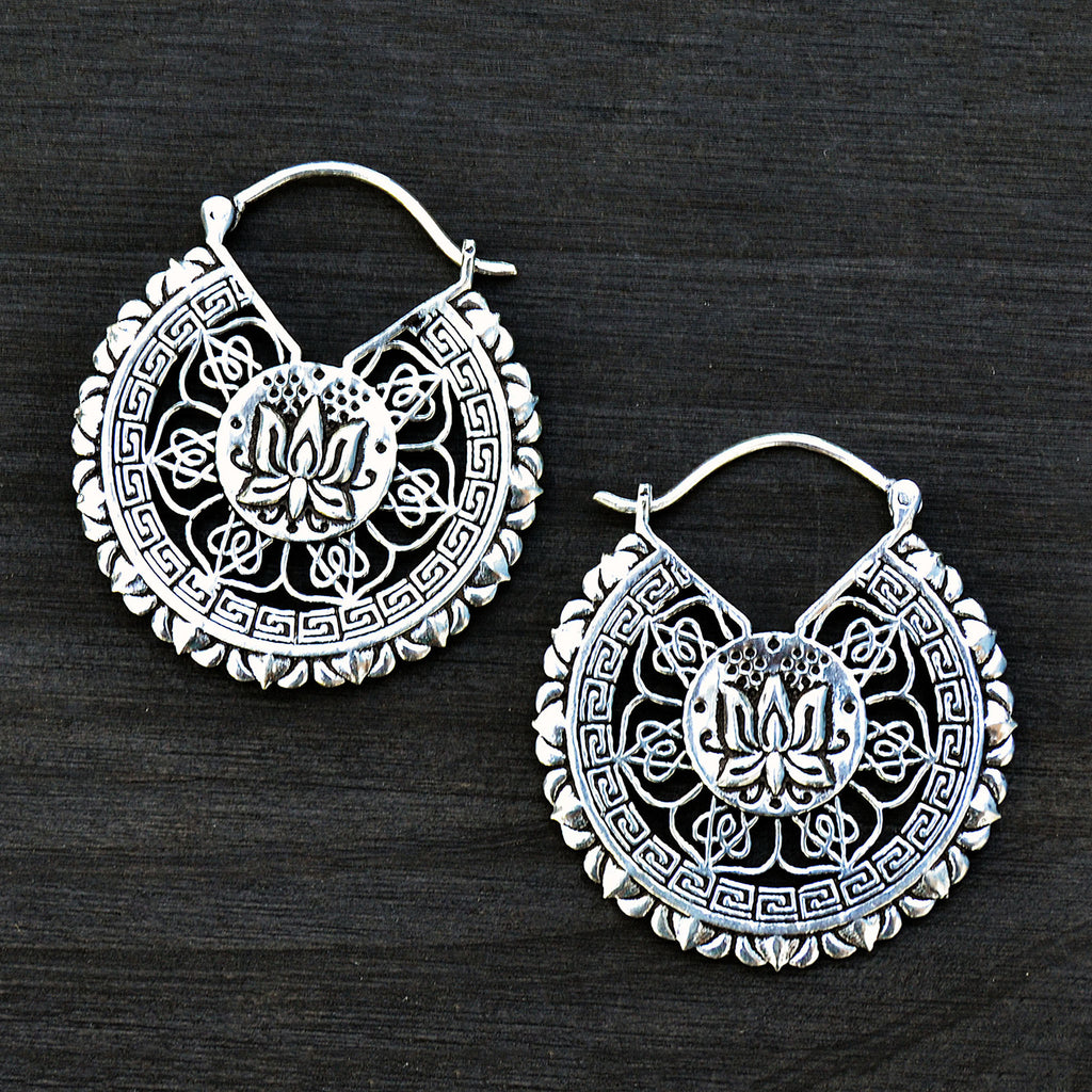 Silver lotus mandala earrings on black background