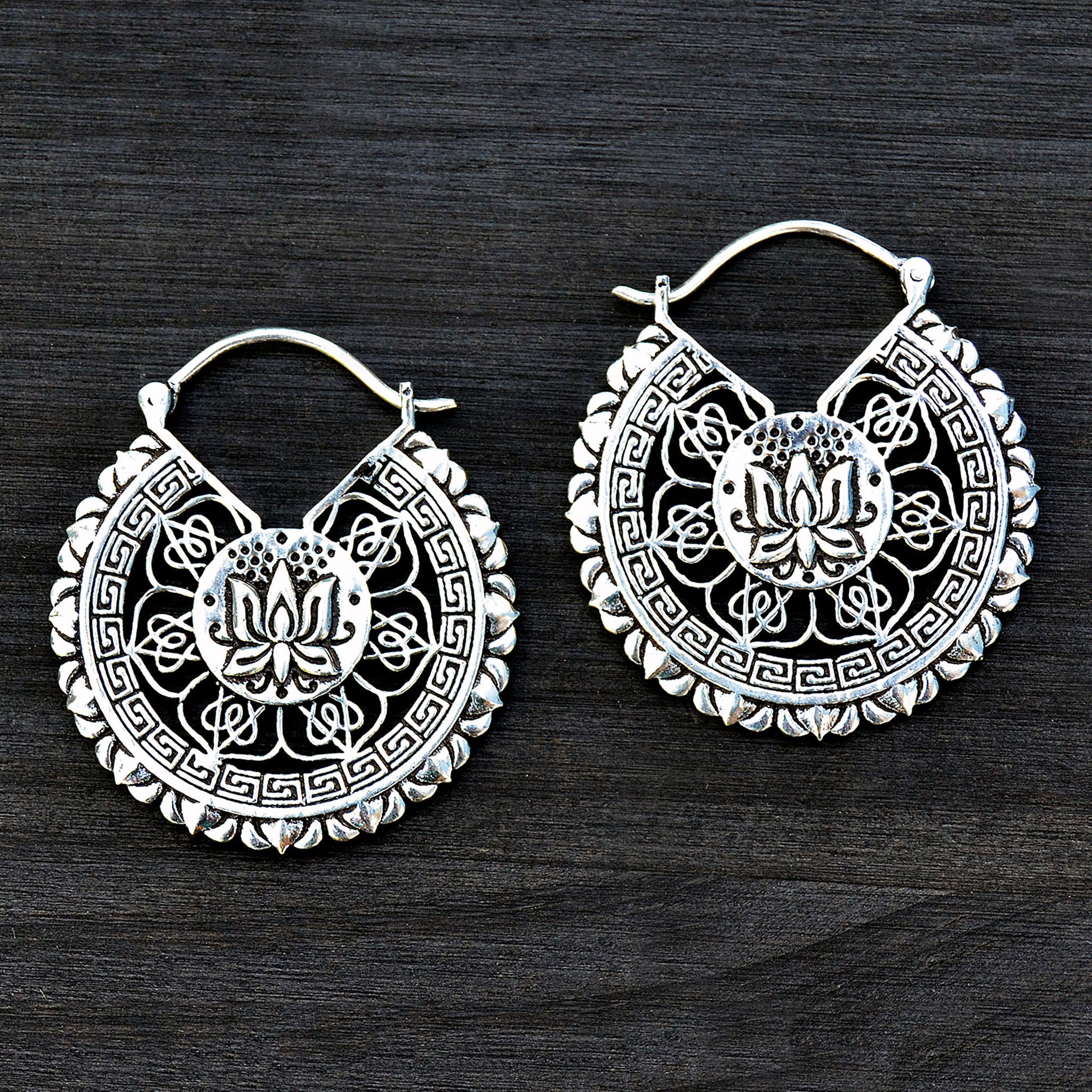 Ethnic lotus mandala earrings on black background