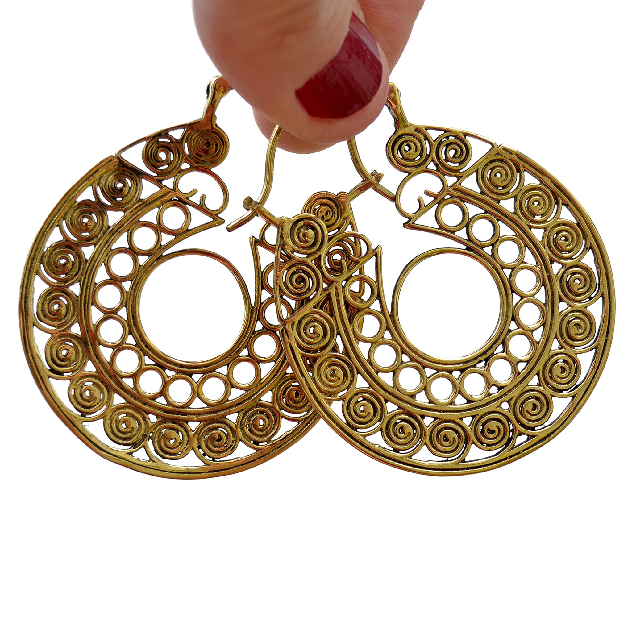 Brass tribal filigree hoop earrings hanging on two fingers