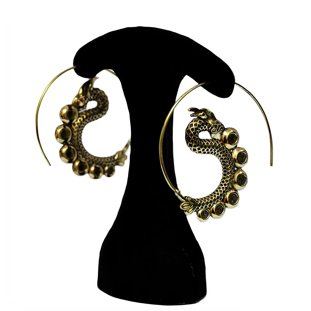 Brass dragon spiral earrings hanging on white background