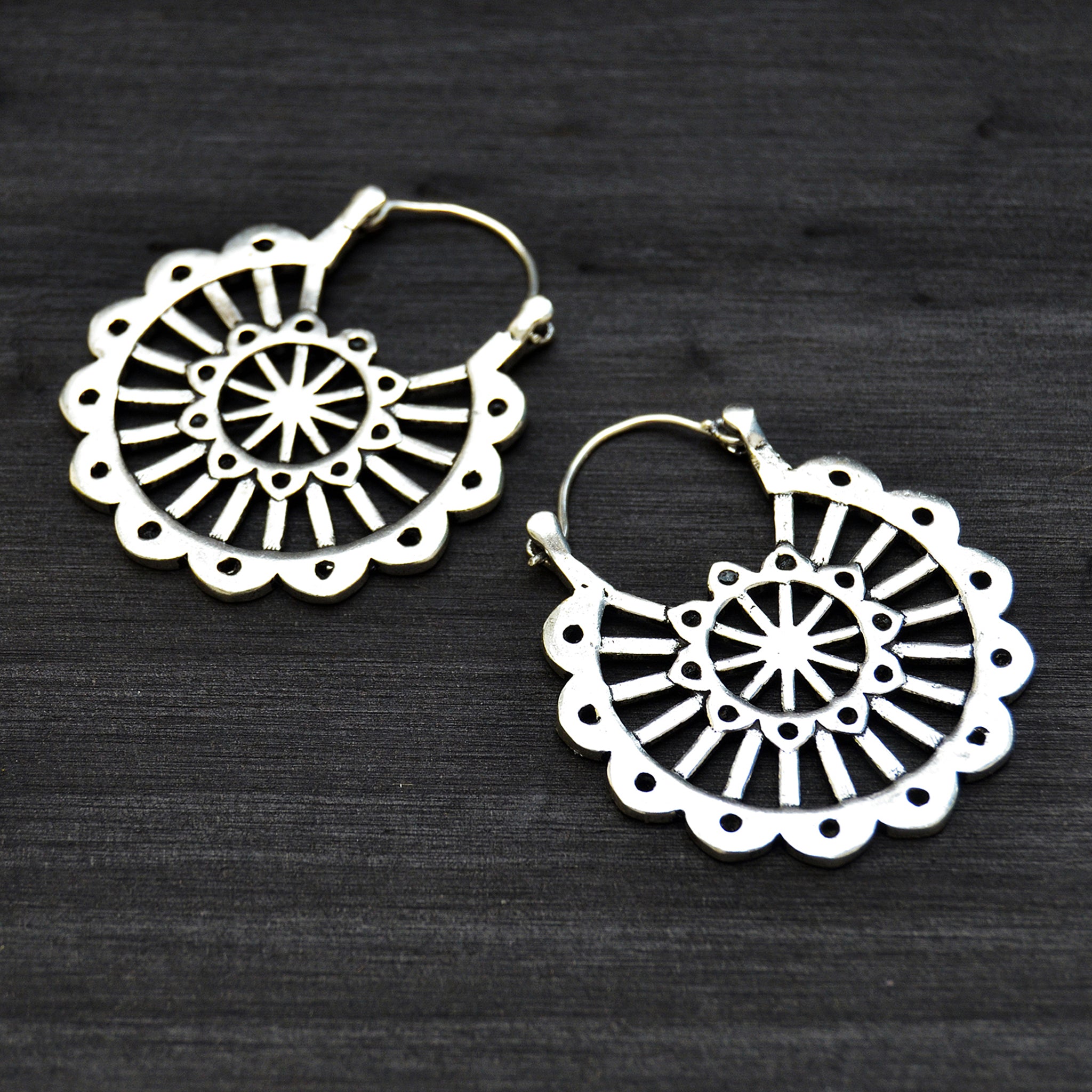Antique mexican silver mandala earrings in black background