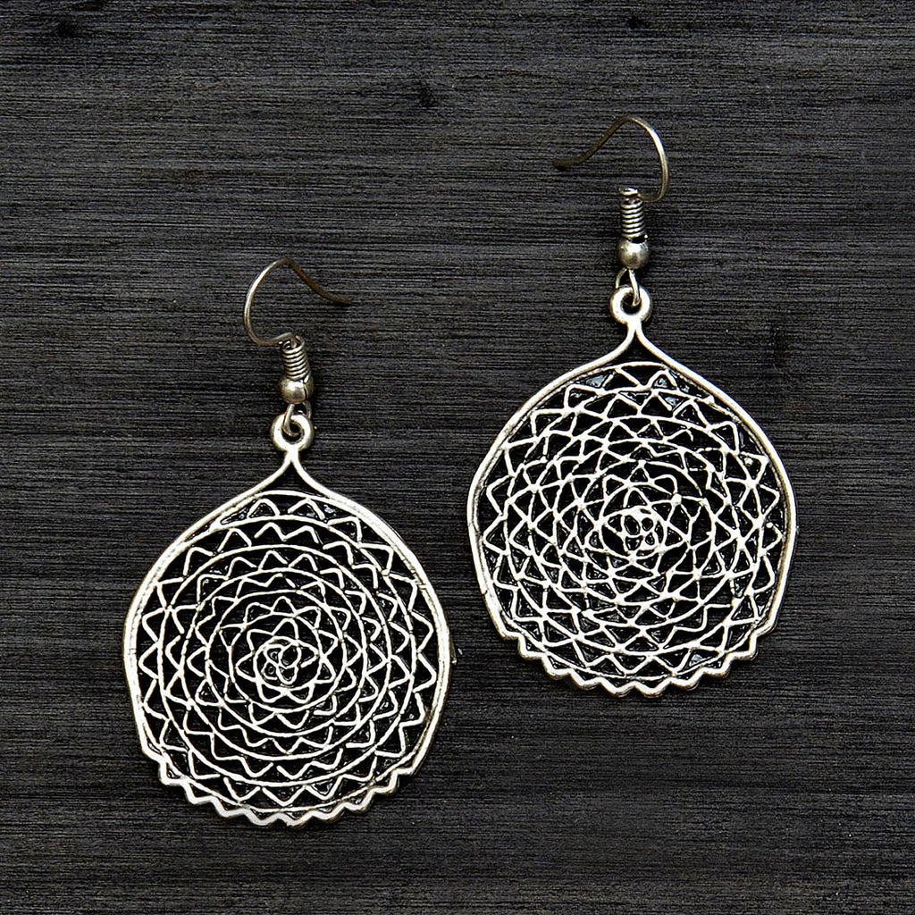 Silver filigree round earrings on gray background