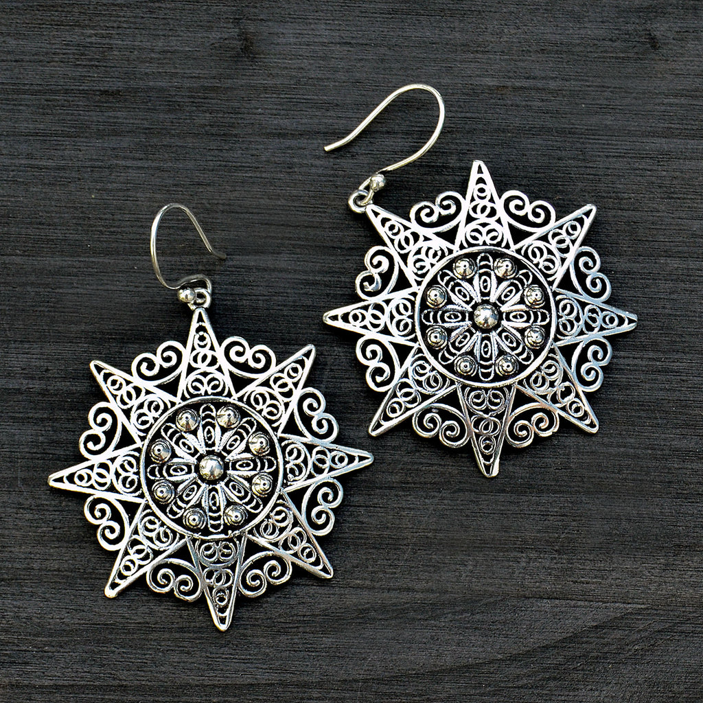 Indian silver filigree mandala earrings on black background