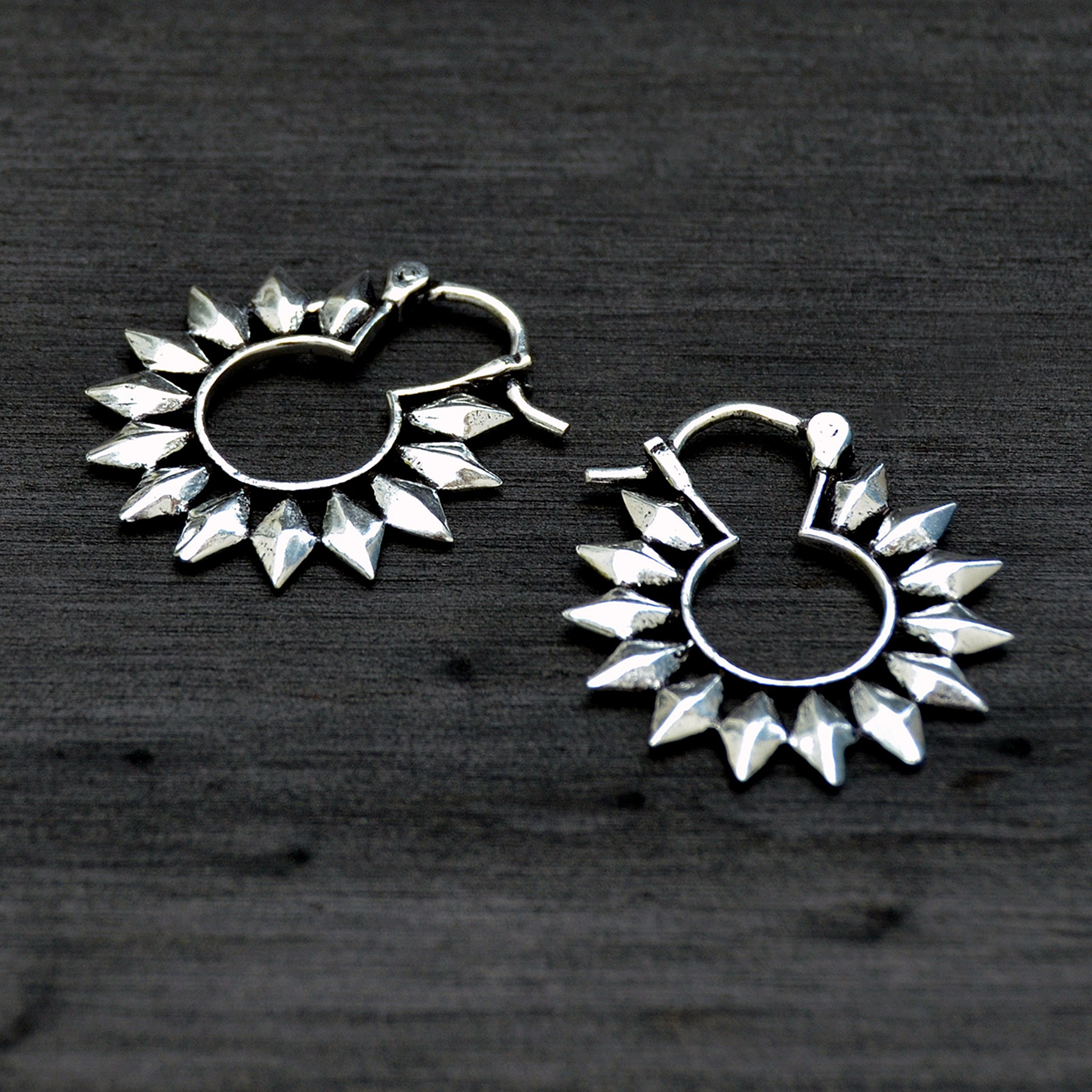 Small silver hoop earrings on black background