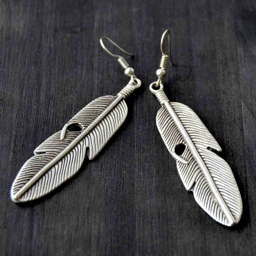Silver feather hook earrings on gray background