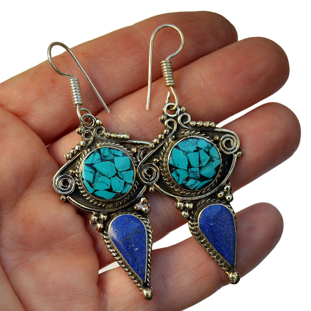 Tribal silver drop earrings with inlay turquoise and lapis lazuli stones on hand