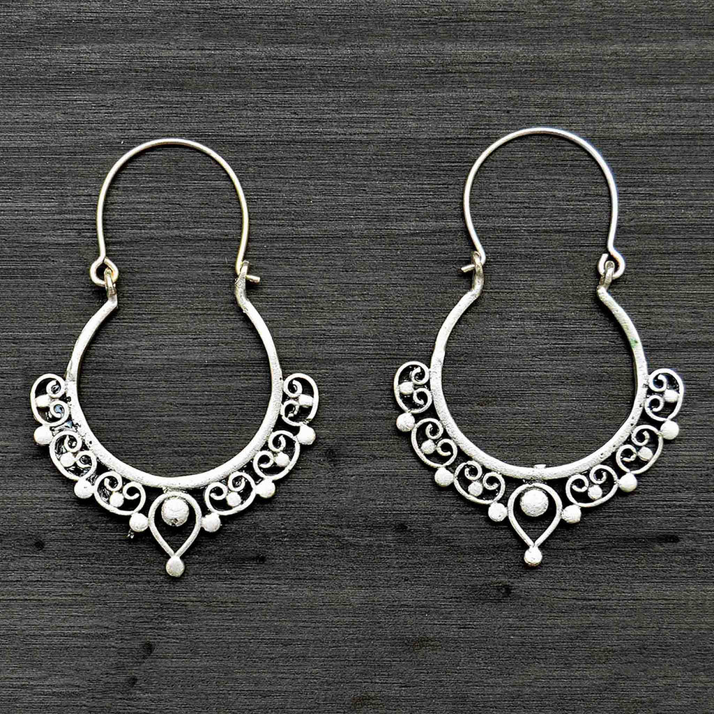 Silver filigree banjara hoop earrings on black background