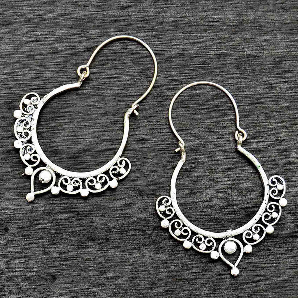 Silver ethnic indian hoop earrings on black background