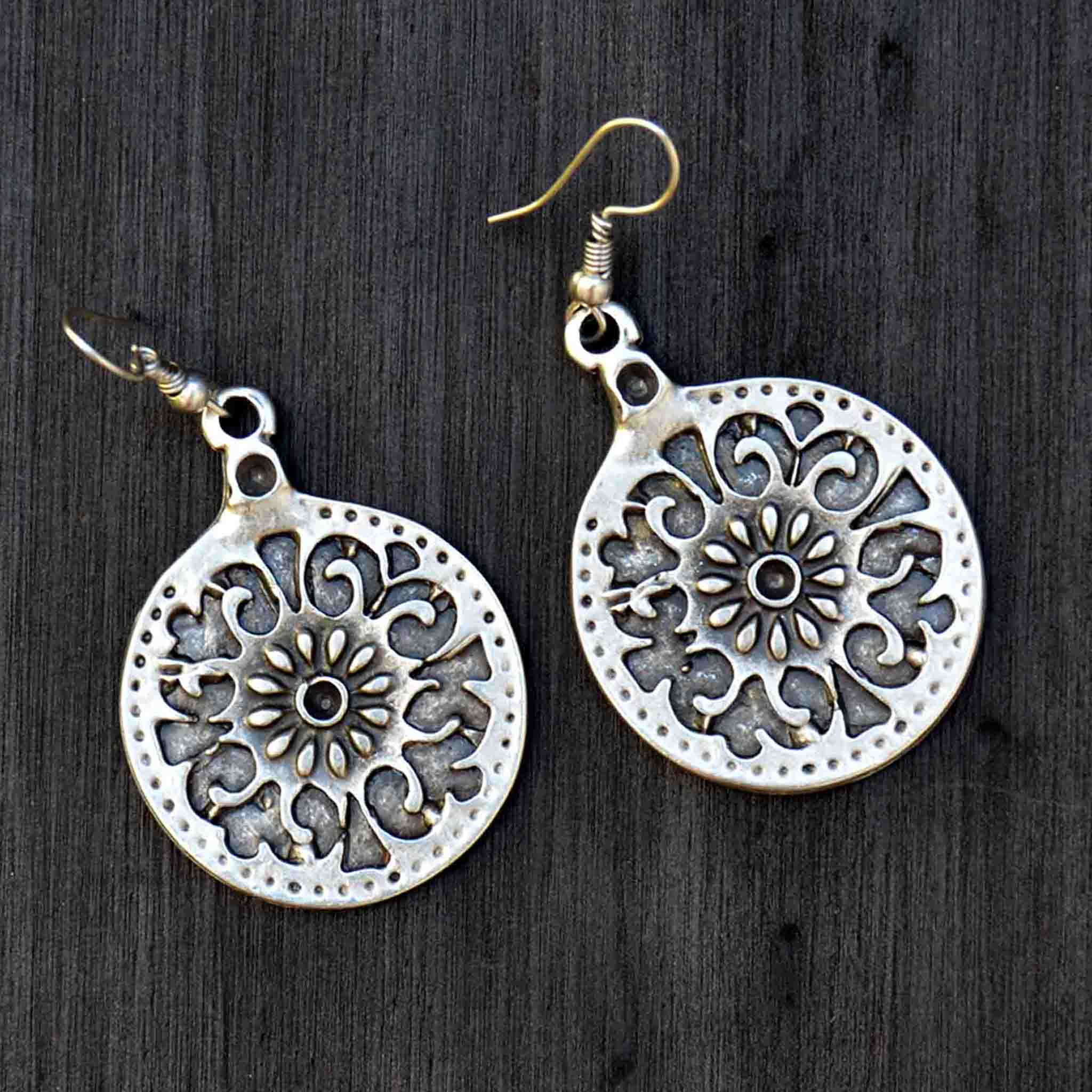 Silver celtic mandala drop earrings on black background