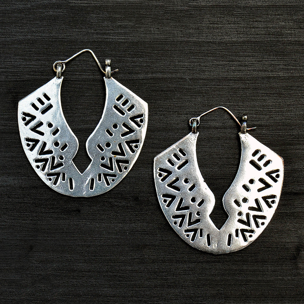 Silver carved hoop earrings on black background