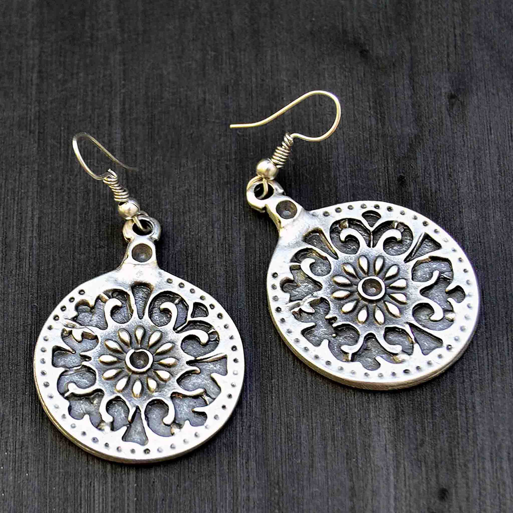 Silver celtic mandala hook earrings on black background