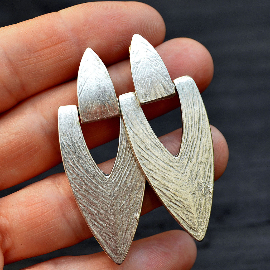 Silver hanging stud edgy earrings on hand