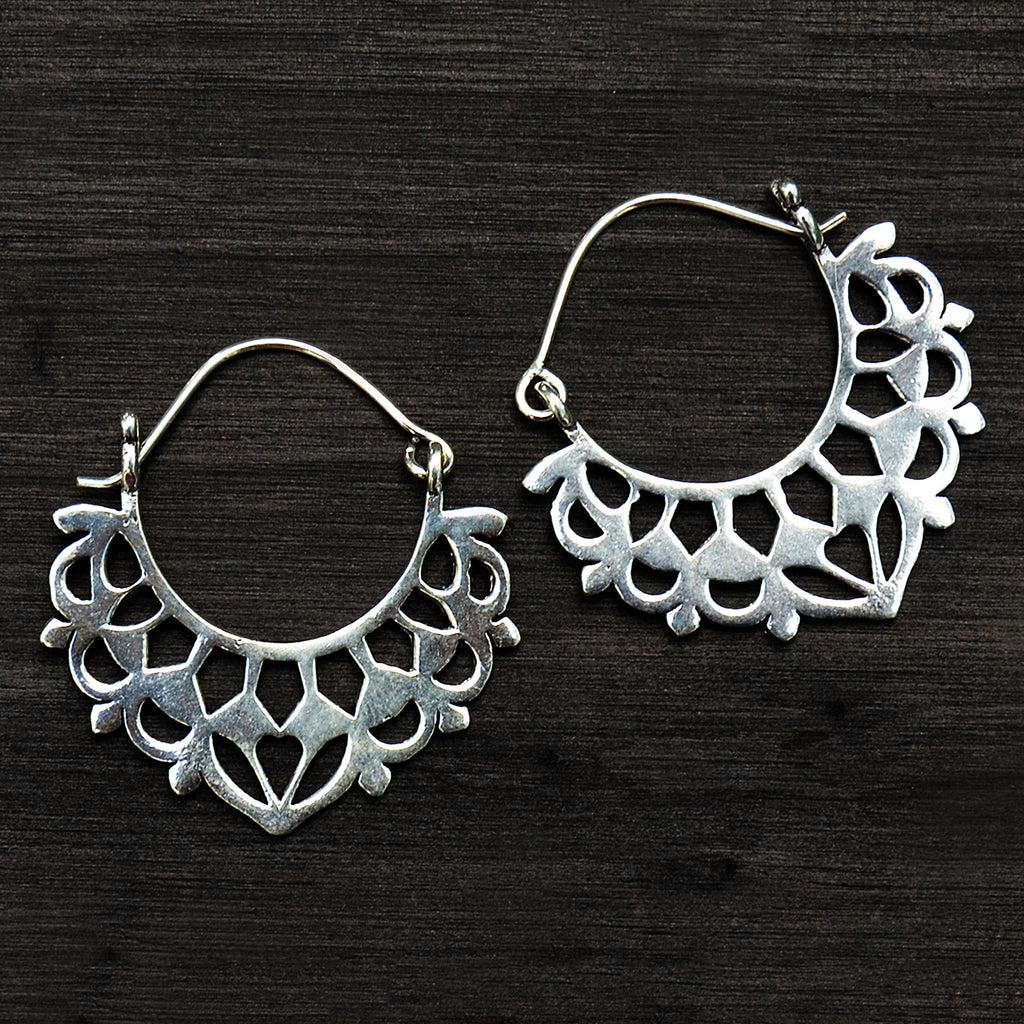 Traditional silver bali earrings on black background