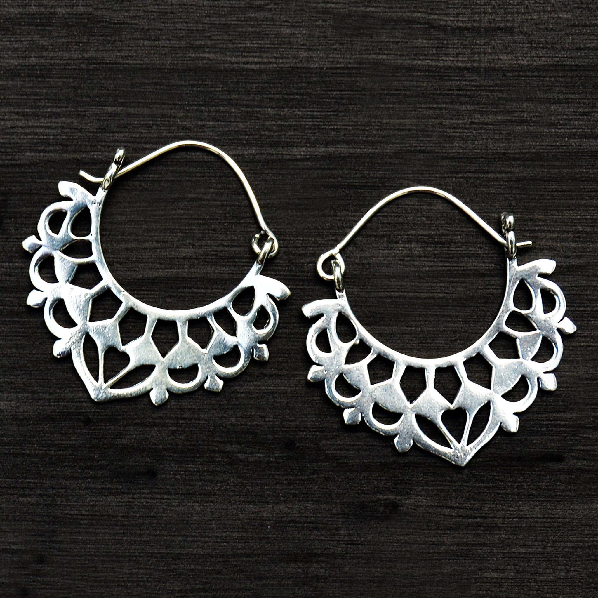 Traditional silver balinese earrings on black background