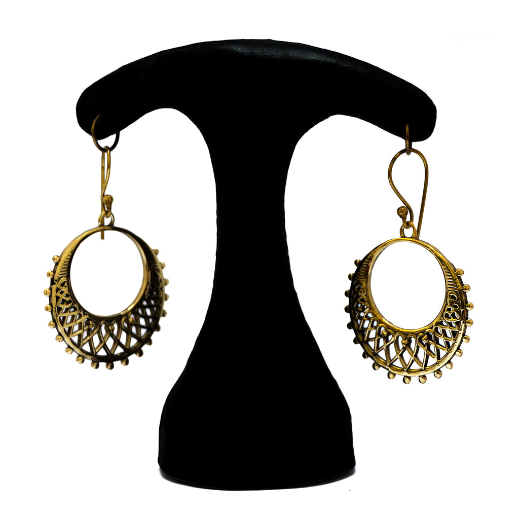 Elegant brass hoop filigree earrings hanging on white background