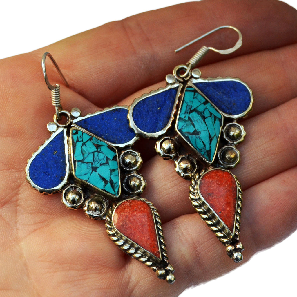 Ethnic silver earrings with inlay turquoise, lapis lazuli and red coral gemstones on hand