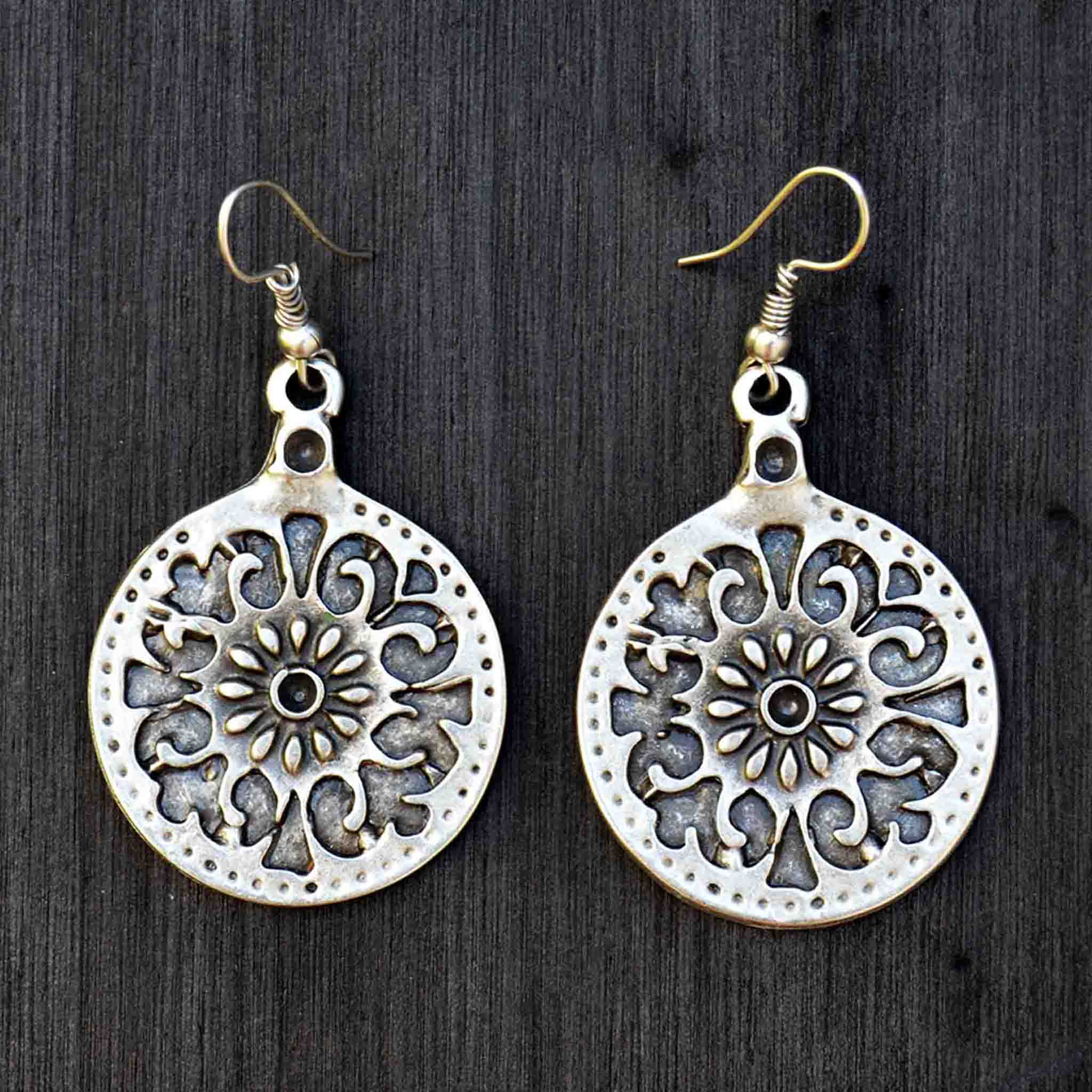 Silver celtic mandala earrings on black background