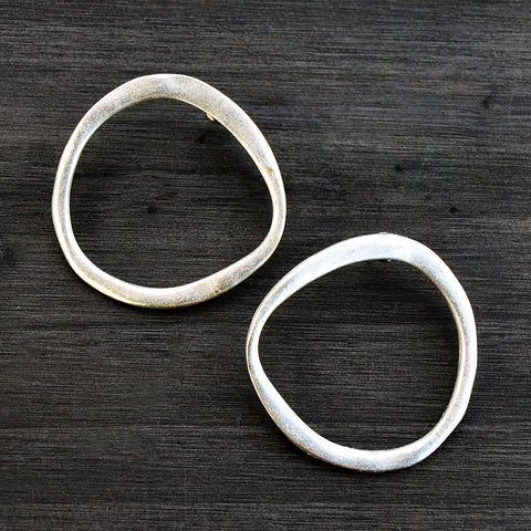 Silver flat hoop earrings on gray background