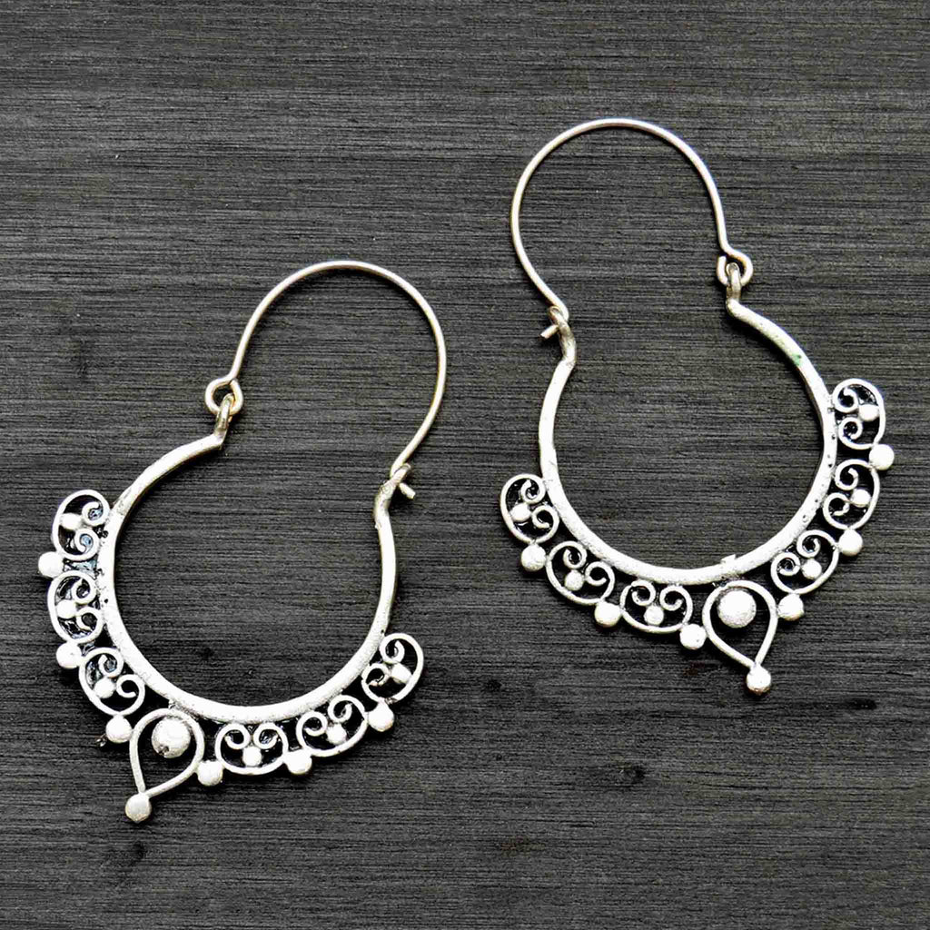 Silver banjara hoop earrings on black background
