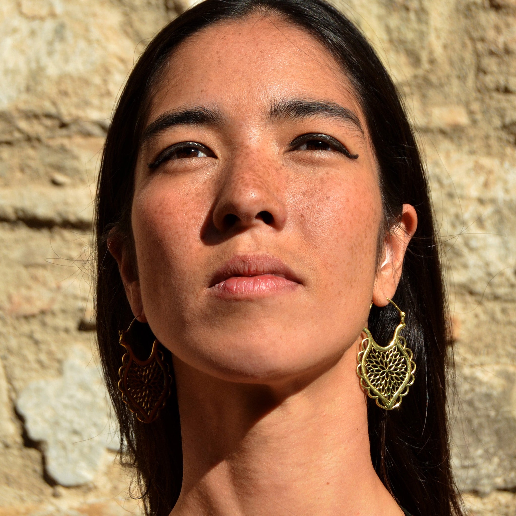 Young woman with gold indian floral earrings