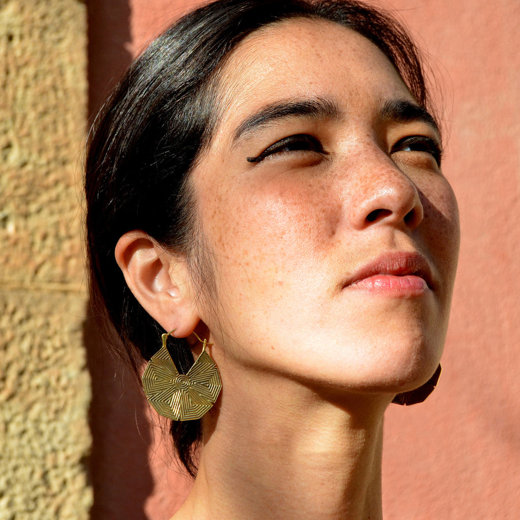 Young woman wearing gold star mandala hoop earrings