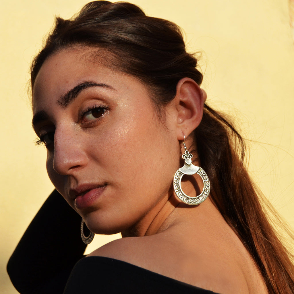 Woman with silver dangle turkish hoop earrings